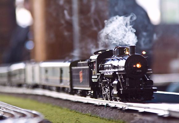 model train on tracks with smoke and greenery showcasing a classic locomotive design ideal for train enthusiasts and collectors celebrating the era of steam engines and railroad history 11 locomotives